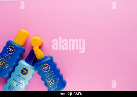 NIVEA SUN products laying on pink flat lay background Stock Photo