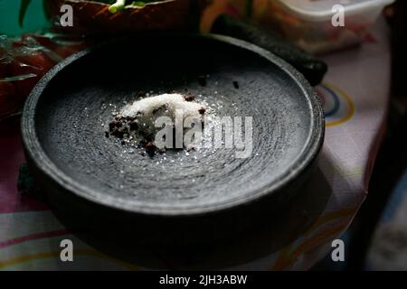 Close up shrimp paste, sugar and salt in stone mortar the ingredients or condiment of sambal Indonesian flavors food Stock Photo