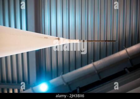 Abstract, close up of Concorde's nose against the background of a hanger with a blue light. Stock Photo