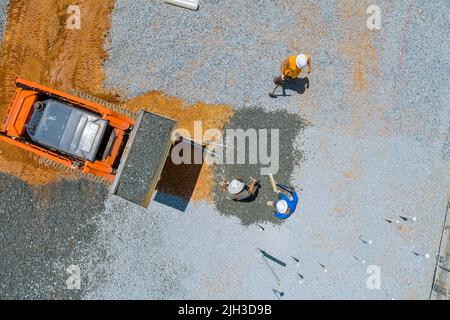 Excavator working in excavator bucket leveling gravel the building foundation on a construction site Stock Photo
