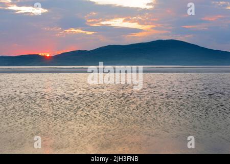 sunset at Seilebost beach on the Isle of Harris with view to Isle of Taransay, Western Isles, Outer Hebrides, Na h-Eileanan Siar, Scotland Stock Photo