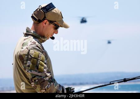 220713-N-N0842-1218 SAN DIEGO (July 13, 2022)  Royal Australian Navy Lt. Cmdr. David Miln, exercise coordinator for Rim of the Pacific (RIMPAC) 2022 Southern California (SOCAL), directs MH-53E Sea Dragon helicopters attached to the 'Vanguards' of Helicopter Mine Countermeasures Squadron (HM) 15, and 'Blackjacks' of HM 14 during a practice run for a RIMPAC SOCAL photo exercise. Twenty-six nations, 38 ships, four submarines, more than 170 aircraft and 25,000 personnel are participating in RIMPAC from June 29 to Aug. 4 in and around the Hawaiian Islands and Southern California. The world’s larges Stock Photo