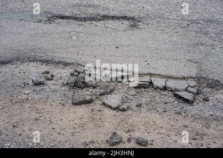 Broken and damaged road surface in the Highlands of Scotland, Uk. Stock Photo