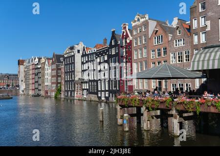 Amsterdam, The Netherlands - 22 June 2022: People eating at a restaurant at Damrak waterfront Stock Photo