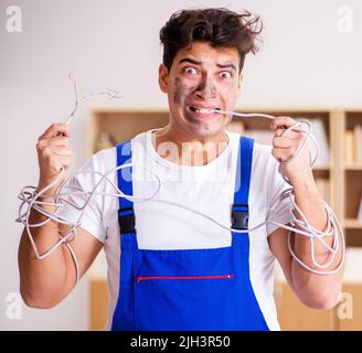 The funny man doing electrical repairs at home Stock Photo