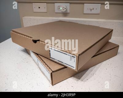 Close up view of two cardboard pizza boxes on a kitchen counter top Stock Photo