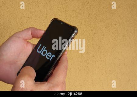 Taubate, SP, Brazil - July 07 2022: hands holding smartphone with Uer logo on the screen  Stock Photo