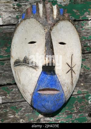 Handmade mask from africa in white, brown and blue painted wood Stock Photo