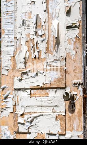 An old wooden door is covered in peeling paint Stock Photo