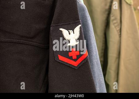 an old navy uniform is on display with a rack of old uniforms from WW2 Stock Photo