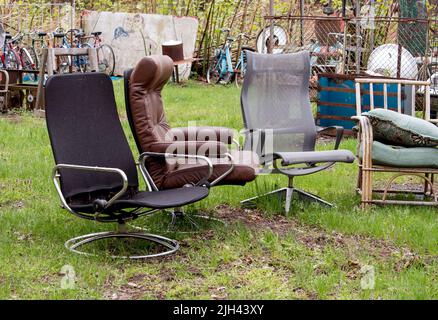 a variety of chairs are for sale at an outdoor yard sale in Michigan USA Stock Photo