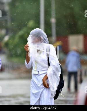 Jammu, Indian-controlled Kashmir. 14th July, 2022. A girl walks in the rain in Jammu, winter capital of Indian-controlled Kashmir, on July 14, 2022. Credit: Str/Xinhua/Alamy Live News Stock Photo