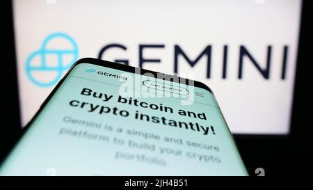 Mobile phone with website of US crypto company Gemini Trust Company LLC on screen in front of business logo. Focus on top-left of phone display. Stock Photo