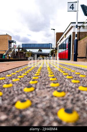 A clever and small way to alert people with vision disabilities that they are close to a danger of some sort, in this case the railway platform edge. Stock Photo