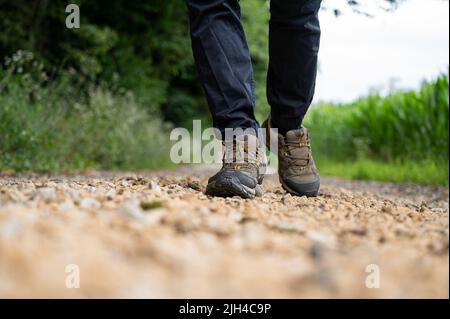 Low angle view of male legs in hiking shoes walking on a trail. Stock Photo
