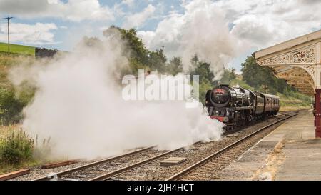 British India Line  vents steam as it is about to set off for linking up to the  diesel hauled part of York to Carlisle Dalesman tour, 14th July 2022 Stock Photo