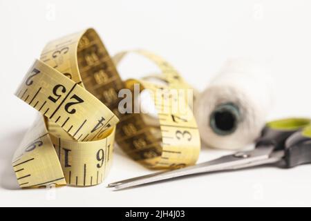 Sewing utensils, scissors, threads, measuring tape isolated on white background. Stock Photo