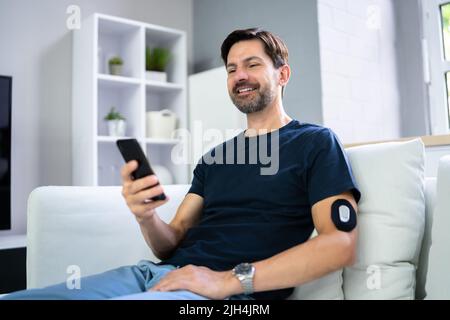 Man Using Continuous Glucose Remote Monitor Diabetes Sensor Stock Photo