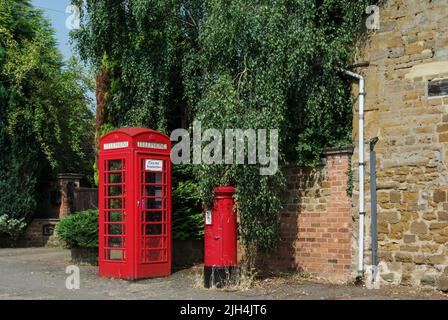 Red phone box and red post box next to each other in the village of Spratton, Northamptonshire, UK Stock Photo