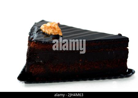 Fudge chocolate cake tart triangular piece made of fudge cake, walnut, butter, vanilla, flour, chocolate and eggs isolated on white background, select Stock Photo