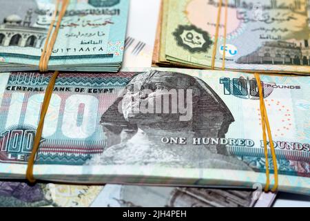 Stack of Egypt money pounds banknotes isolated on white background, Pile of Egyptian pounds cash money bills with rubber bands of 200 LE, 100, 50, 20, Stock Photo