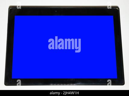 Large black tablet on a white background with a blue screen. Stock Photo