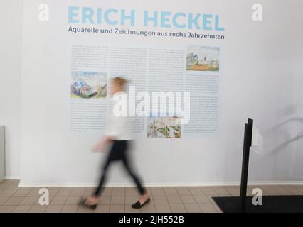 Apolda, Germany. 15th July, 2022. Nadine Stephan, curator of the exhibition, walks past a poster in the exhibition 'Erich Heckel - Watercolors and Drawings from Six Decades'. The exhibition takes place from 17.07. to 11.09.2022 in the Kunsthaus Apolda Avantgarde. Credit: Bodo Schackow/dpa/Alamy Live News Stock Photo