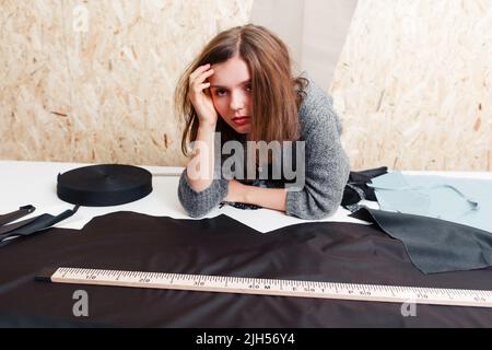 Stressed pattern cutting designer at workplace Stock Photo
