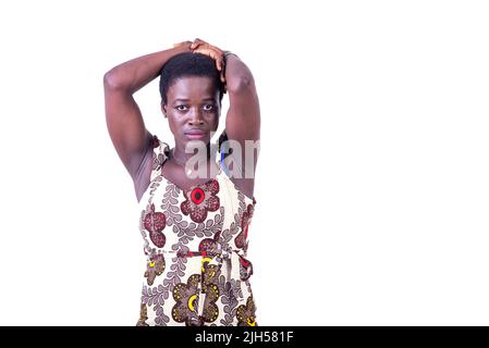 a beautiful young african woman in loincloth dress standing on white background holding her hands on her head and looking at the camera Stock Photo