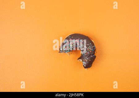 half eaten donuts and coffee mug on orange background  Stock Photo