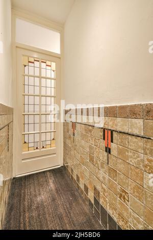 Interior of modern flat in minimal style with narrow empty corridor illuminated by lamps Stock Photo