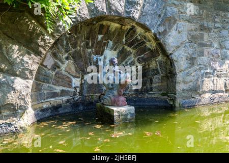 Japanese red carps in the pond in New Jersey Botanical Garden Sculpture on the background Stock Photo