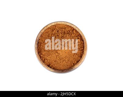 Top view of a wooden bowl full of ground red pepper on a white background. Copy space. Stock Photo