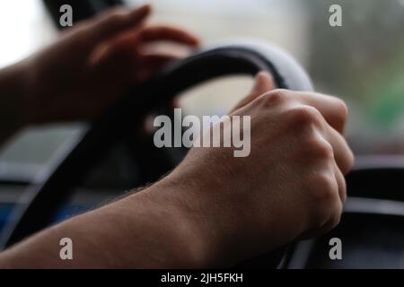 Defocus male hand holding steering wheel. A man's hand handle steering wheel car for driving. Traffic jam, driving car on highway, close up of hands o Stock Photo