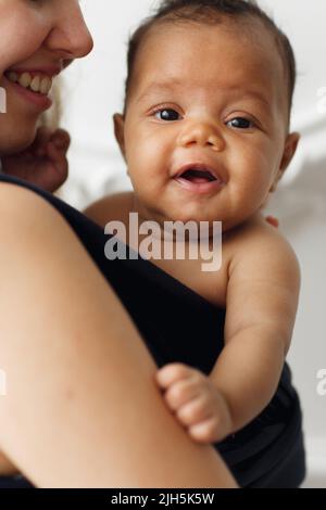 Smiling adorable baby with happy mother in sling Stock Photo