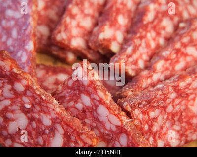 Smoked sausage, full frame. Pieces of appetizing meat snack close-up. Sliced sausage as background, meat delicatessen Stock Photo