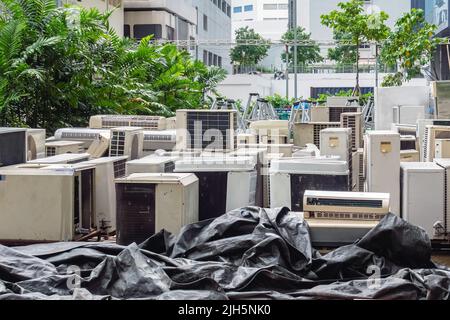 A lot of Air conditioners stacked up in a pile to disposal at recycling garbage dump. Stack of old and dirty air conditioners defective and discarded Stock Photo