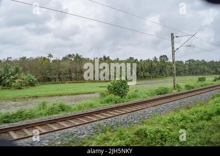 view of Indian railway track passing through rural place Stock Photo