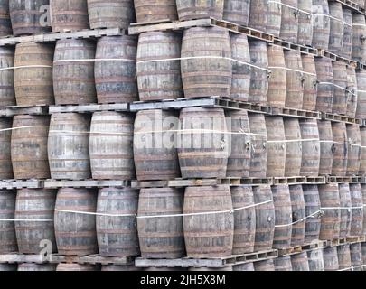 Whisky casks stacked at distillery for storage Stock Photo