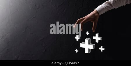 Hand hold 3D plus icon, man hold in hand offer positive thing such as profit, benefits, development, CSR represented by plus sign.The hand shows the p Stock Photo