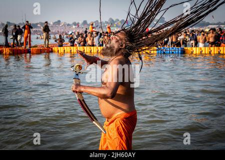 A Hindu man with long dreadlocks and carrying a sword bathes at the Triveni Sangam at the Kumbh Mela Festival in Allahabad (Prayagraj), India. Stock Photo