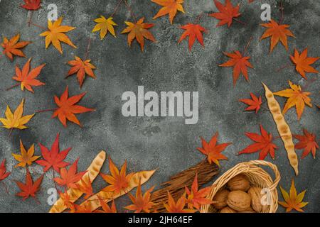 Frame concept made of fall maple leaves, walnuts on dark background. Autumnal season. Flat lay, top view Stock Photo