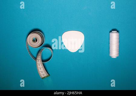 Blue textured background with sewing tools, copy space on background. Frame with sewing tools and accessories. Top view. Stock Photo