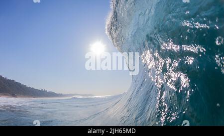 Ocean wave upright sea water swimming encounter face to face towards morning sun reflections crashing breaking blue water with clear sky scenic photo. Stock Photo