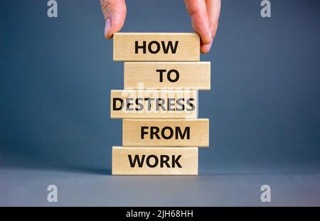 Destress from work symbol. Concept words How to destress from work on wooden blocks. Doctor hand. Beautiful grey background. Psychological business an Stock Photo