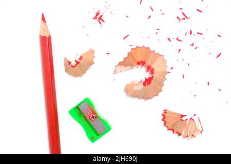 Sharpener and sharpened red pencil with sawdust on white background Stock Photo