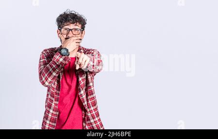 Attractive person laughing at you, young man pointing at camera with hand over mouth, concept of man making fun of you isolated Stock Photo