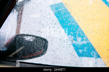 Raindrops on the side window of a car, Close up of raindrops on the window of a car, Macro of drops of water on the windows of a car Stock Photo