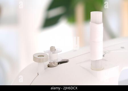Winding threads on a bobbin on a sewing machine. Stock Photo