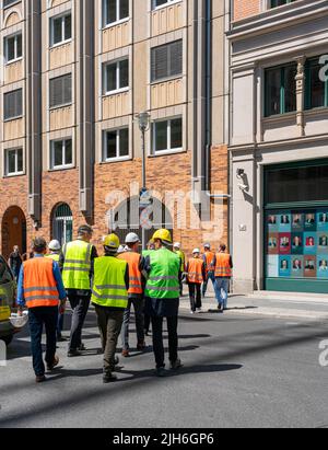 Construction workers with safety waistcoats in green and orange, Berlin, Germany Stock Photo